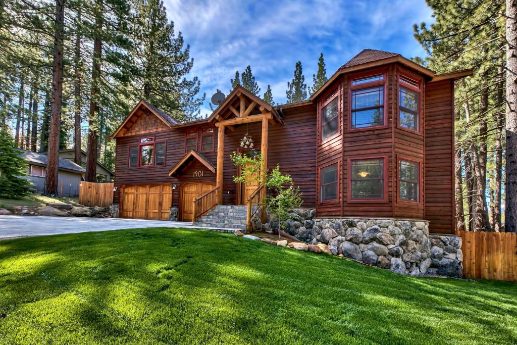 a log home with a green yard at Blackfoot Luxury Retreat - Hot Tub Pool Table Pets Deck in South Lake Tahoe