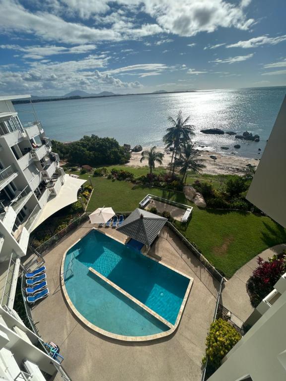 an aerial view of a swimming pool and the ocean at Coral Cove Apartments in Bowen