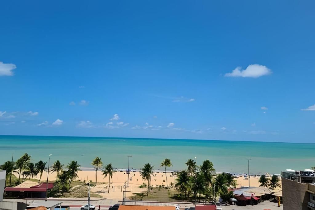 a view of a beach with palm trees and the ocean at Apto em Tambaú no coração turístico da cidade ! in João Pessoa