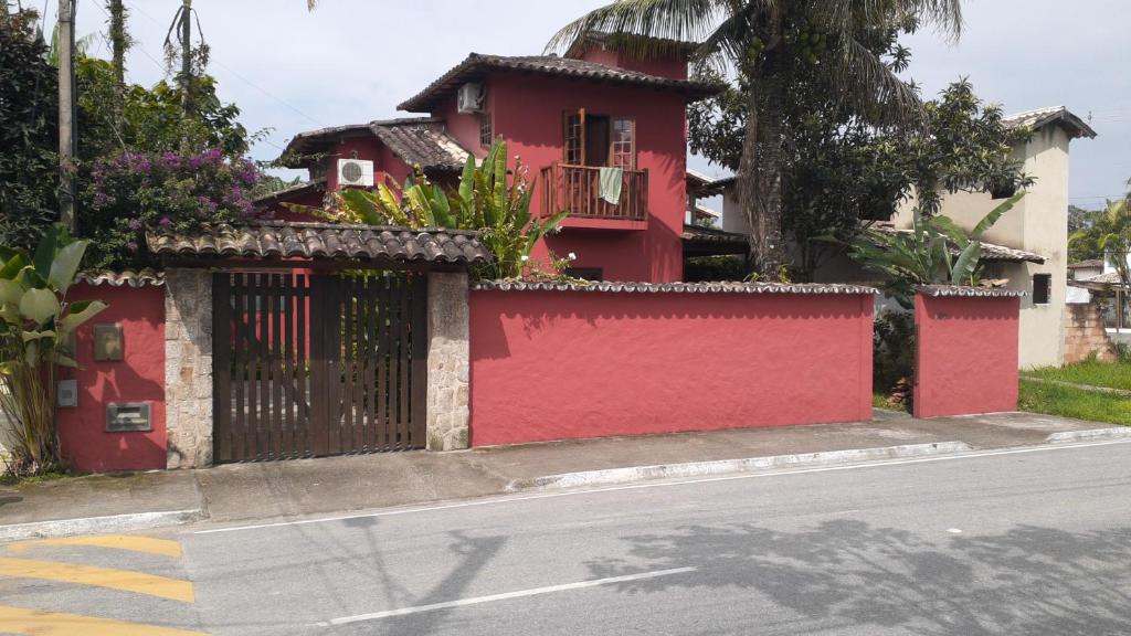a red house with a fence on the side of a street at Casa Portal in Paraty