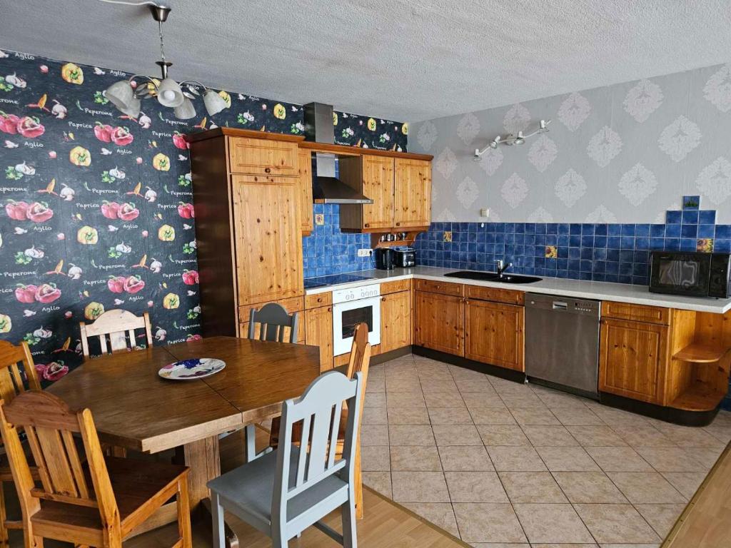 uma cozinha com uma mesa de madeira e uma sala de jantar em Kompfort Business Apartment em Wertheim