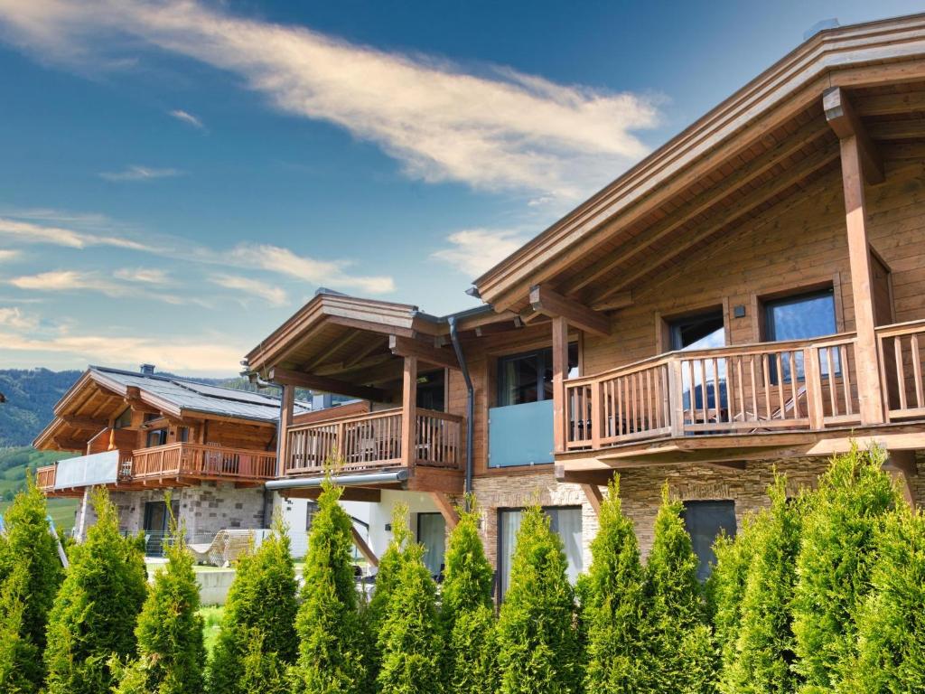 Cette maison en rondins comprend un balcon et des arbres. dans l'établissement BergbiberLODGE S, à Piesendorf