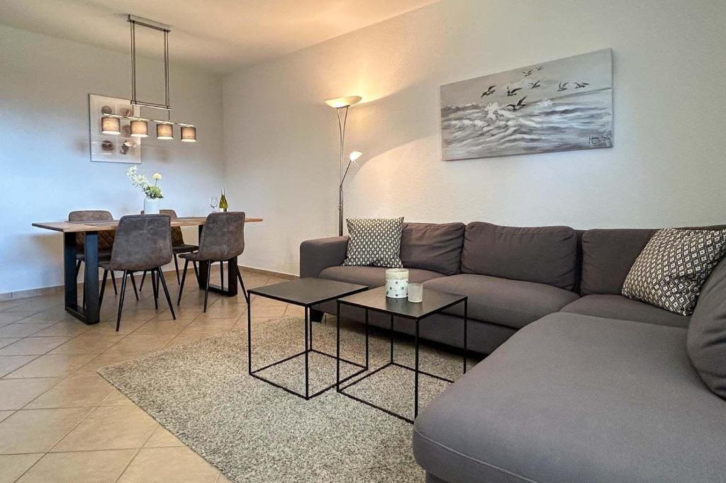 uma sala de estar com um sofá e uma mesa em Ferienwohnung-9-mit-Terrasse-Garten-Landhaus-Hubertus-Duhnen em Cuxhaven