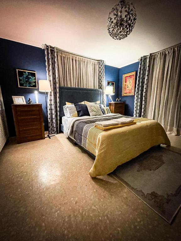 a bedroom with a large bed with blue walls at ORHO HOTEL BOUTIQUE PANAMA Tocumen Airport free shuttle highway round trip 15 minuts in Tocumen