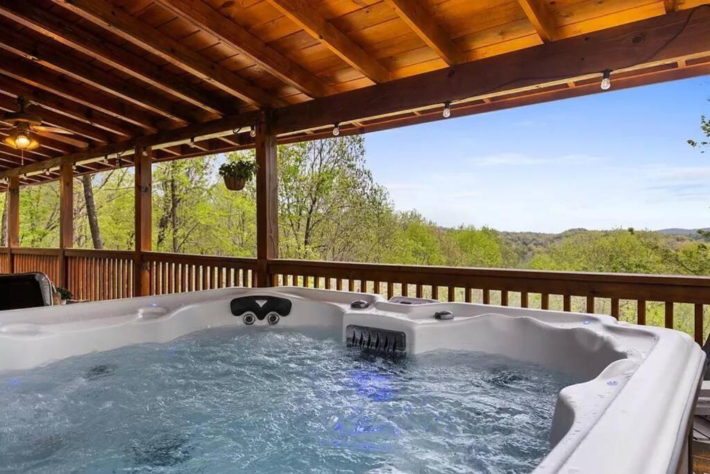a hot tub on the deck of a house at Charley Brown Cabin in Cherry Log