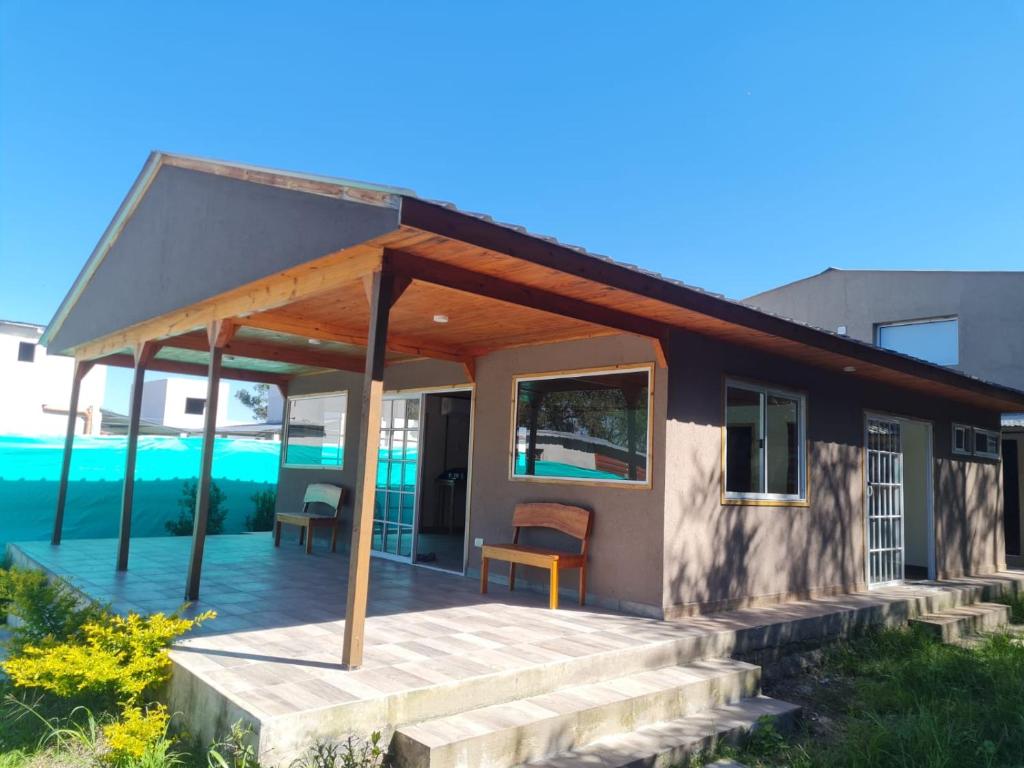 ein kleines Haus mit einer Veranda und einer Terrasse in der Unterkunft Cabañas La Estrella in Salta