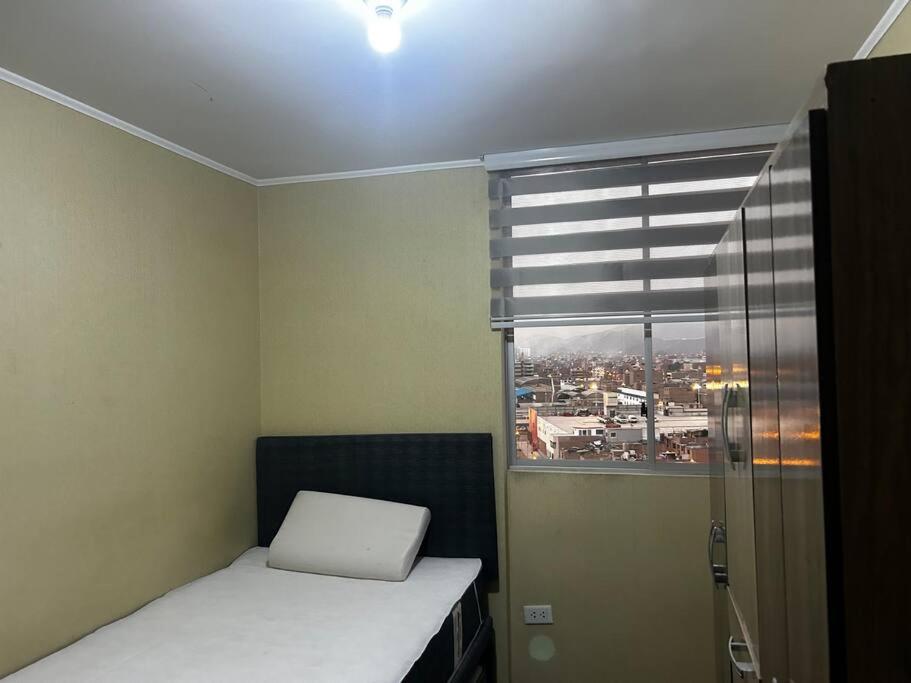 a small room with a bed and a window at Departamento familiar en el centro de Lima Perú in Lima