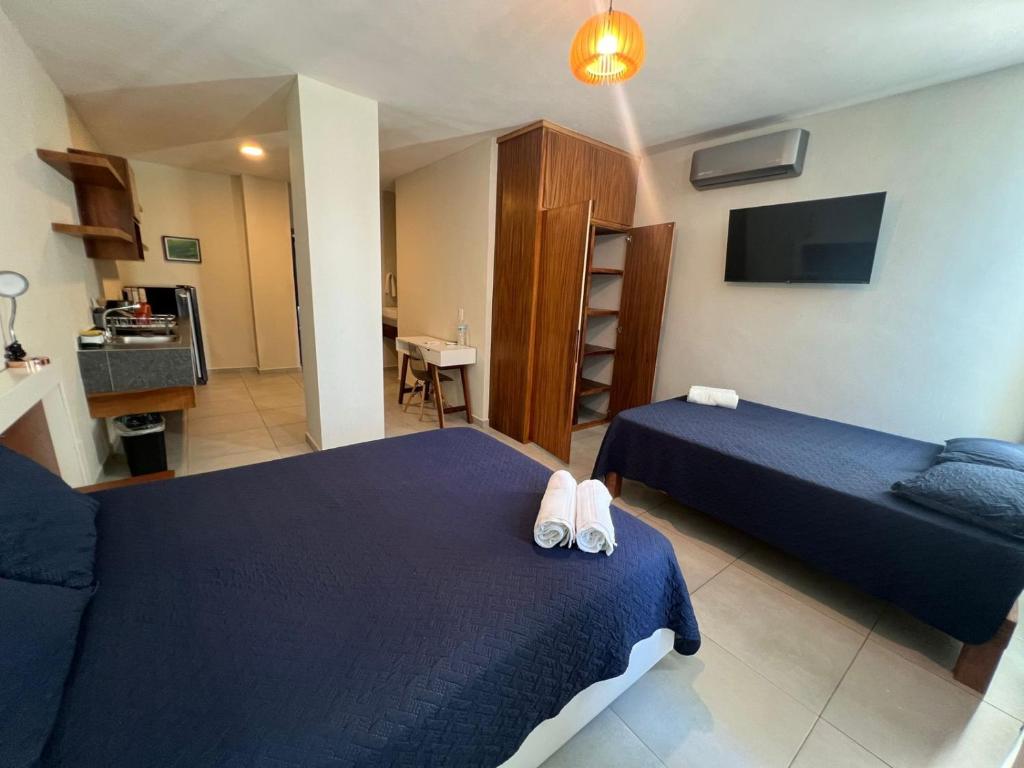 um quarto de hotel com duas camas e uma televisão em Kavalá em San Blas