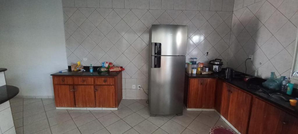 uma cozinha com um frigorífico de aço inoxidável e armários de madeira em Aluguel de quartos em residencia em Gurupi