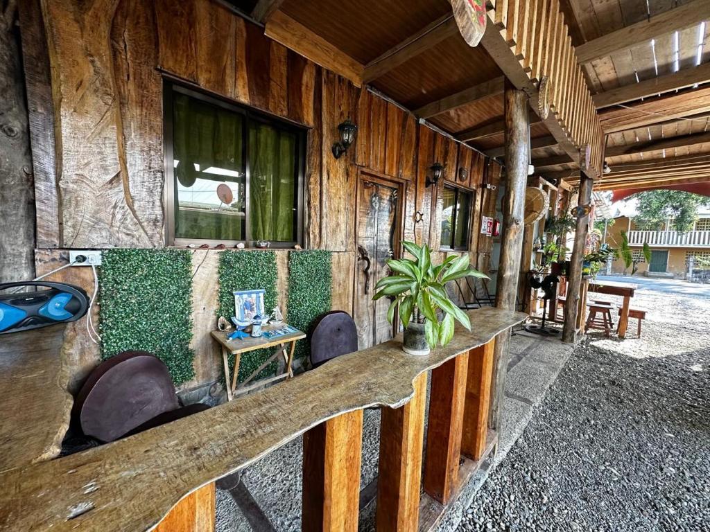 eine Veranda eines Holzhauses mit einem Tisch und Stühlen in der Unterkunft Mochileros MarAbi in Tarcoles