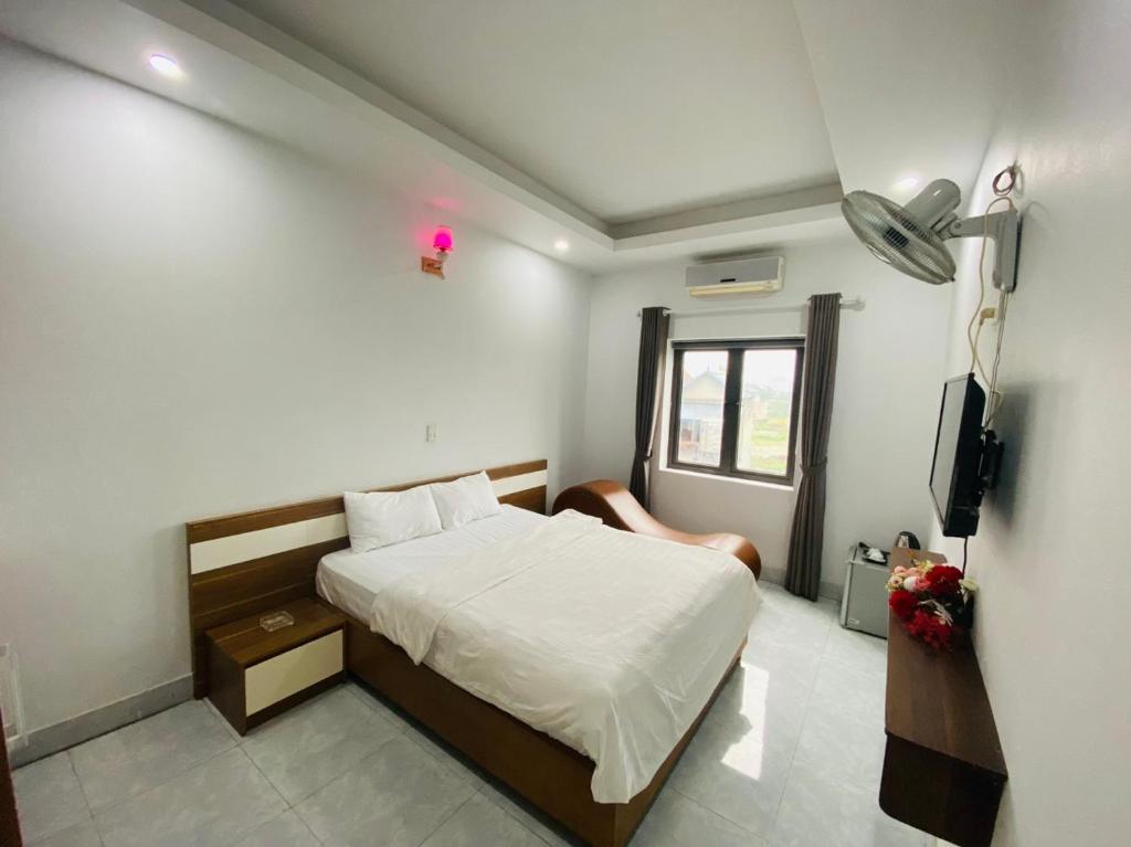 1 dormitorio con 1 cama y TV. en Khách sạn Phú Hưng, en Thái Nguyên