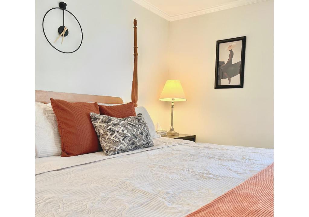 a bedroom with a bed and a clock on the wall at Cozy Villa 3 mins to Mohegan- Fully Stocked with King Bed & Fireplace- Jacuzzi, Saltwater Pools, Sauna in Norwich