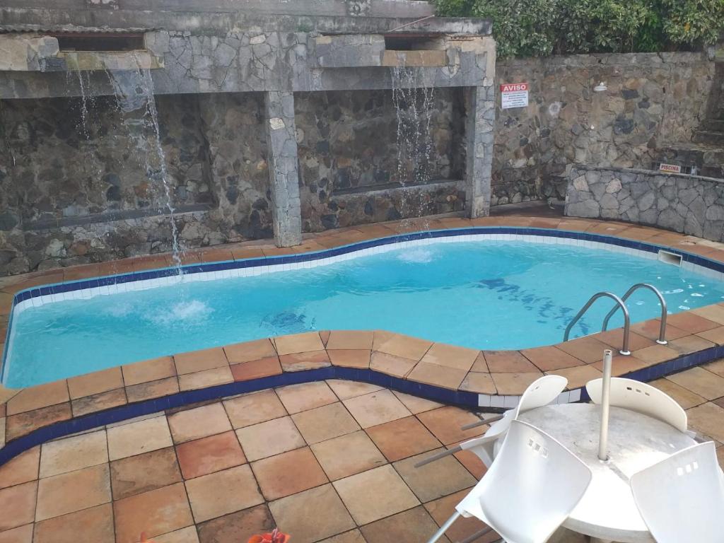 una piscina con una fuente de agua en ESCAPE PARA O PARAISO, Casa Mobiliada com PISCINA e Salão de jogos, 300mt da PRAIA en Arraial do Cabo