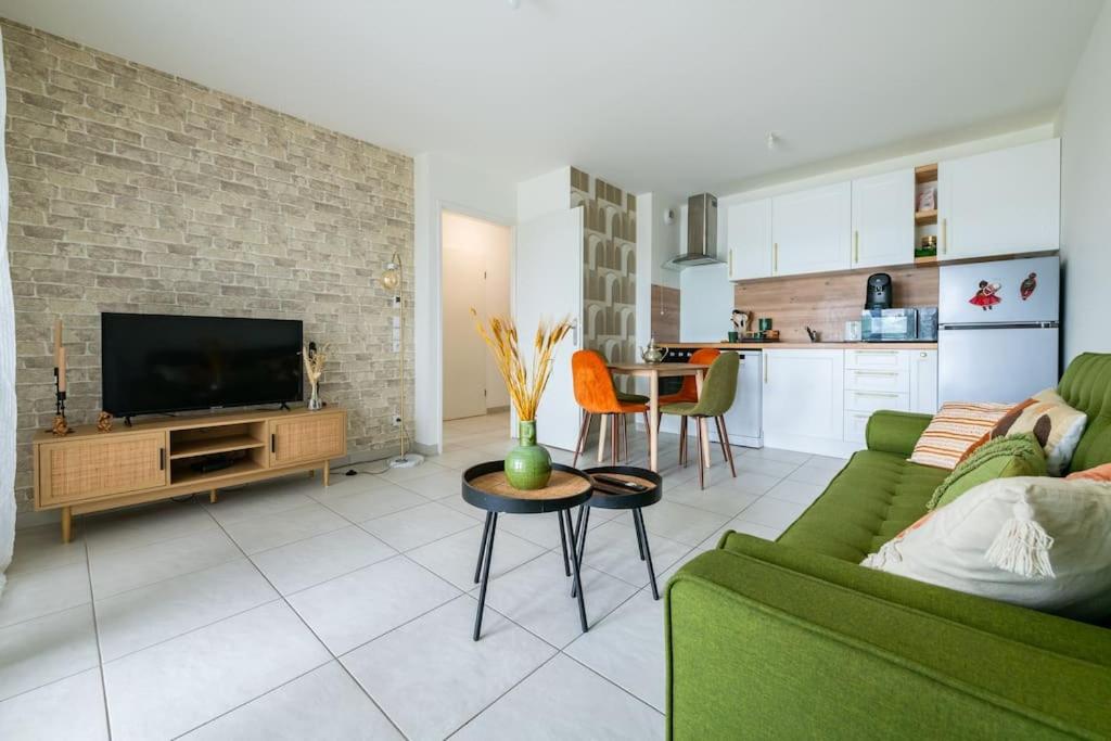 Il comprend un salon avec un canapé vert et une cuisine. dans l'établissement Le Havre de Sérénité - Orly - Gare - Place privée, à Athis-Mons