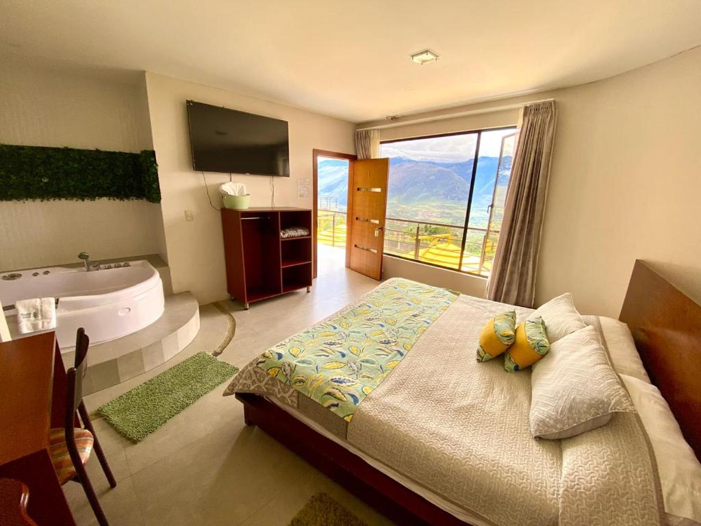 a bedroom with a bed and a tub and a television at Hostería Paradero Yunguilla in Santa Isabel