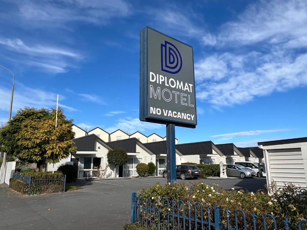 una señal para un motel drupal en un estacionamiento en Diplomat Motel, en Christchurch