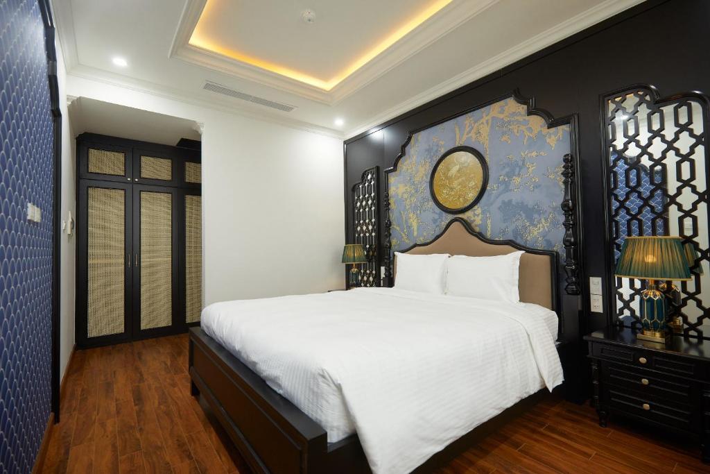 a bedroom with a large white bed and a blue wall at Union Inn+ in Ha Long