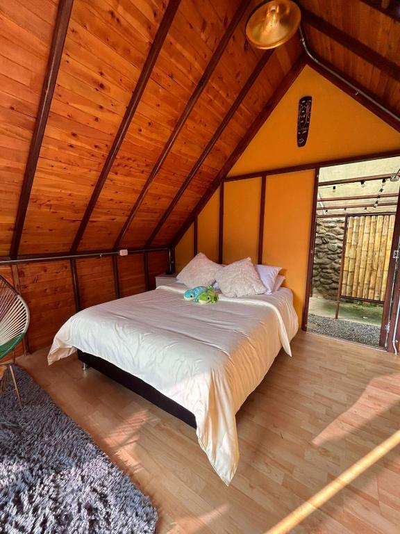 a bedroom with a bed in a room with wooden ceilings at Glampling Dos Quebradas in Floridablanca