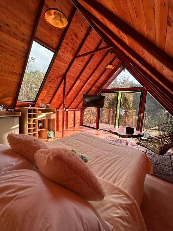 a bedroom with a large bed in a room with windows at Glampling Dos Quebradas in Floridablanca