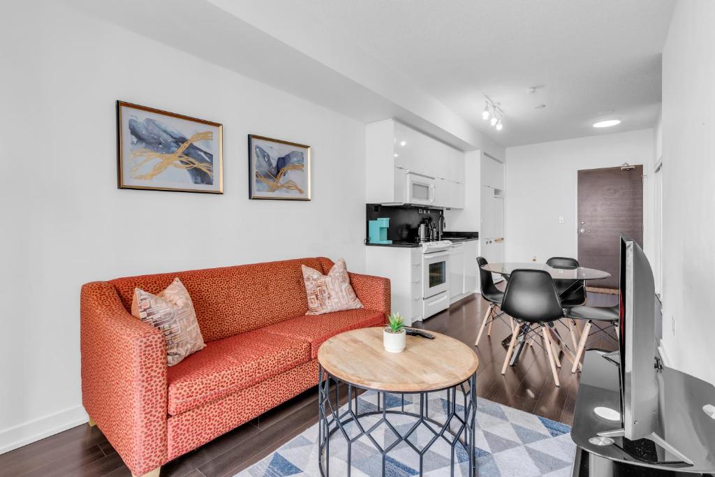 uma sala de estar com um sofá e uma mesa em Downtown Condo - Free Parking/Self Check-in em Toronto