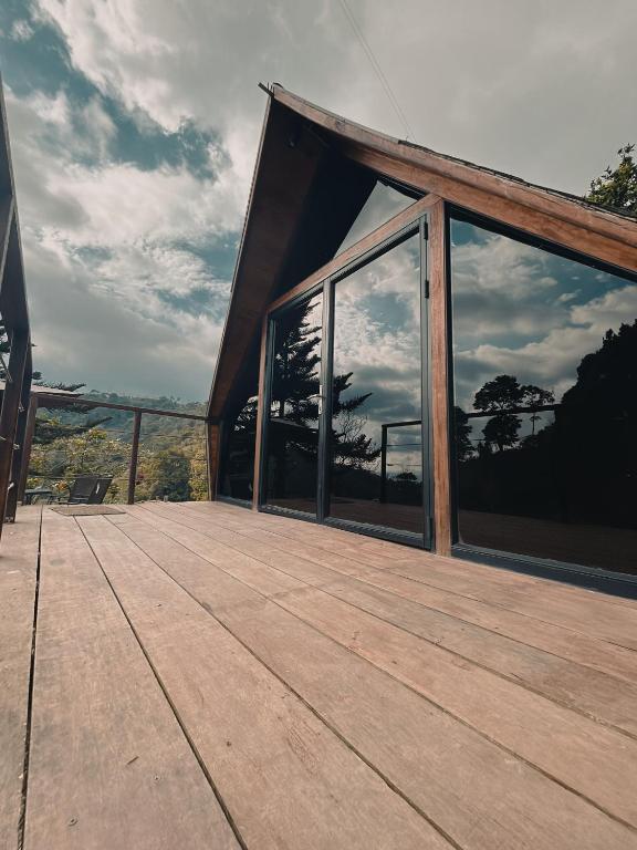 a house with a deck with large glass windows at Glampling Dos Quebradas in Floridablanca