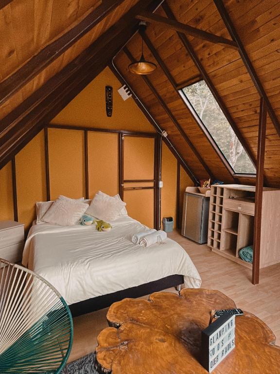 a bedroom with a large bed in a attic at Glampling Dos Quebradas in Floridablanca