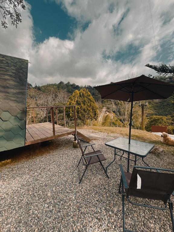 a patio with a table and an umbrella at Glampling Dos Quebradas in Floridablanca
