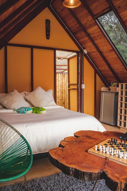 a bedroom with a bed with a chess board and a table at Glampling Dos Quebradas in Floridablanca