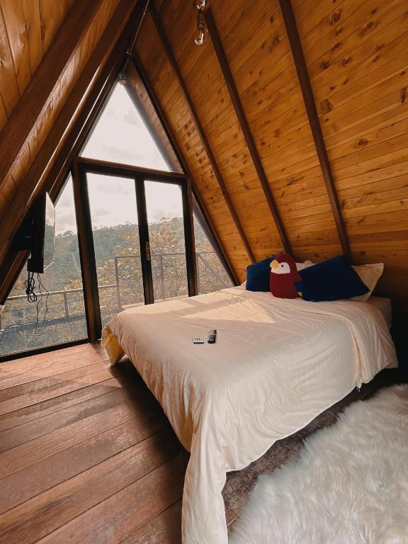 a bed in a room with a large window at Glampling Dos Quebradas in Floridablanca