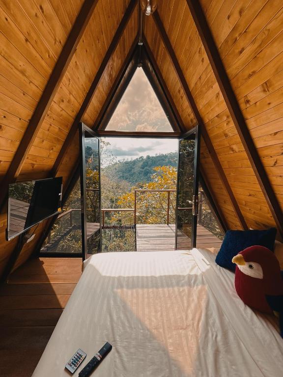 a bedroom in a tree house with a large window at Glampling Dos Quebradas in Floridablanca