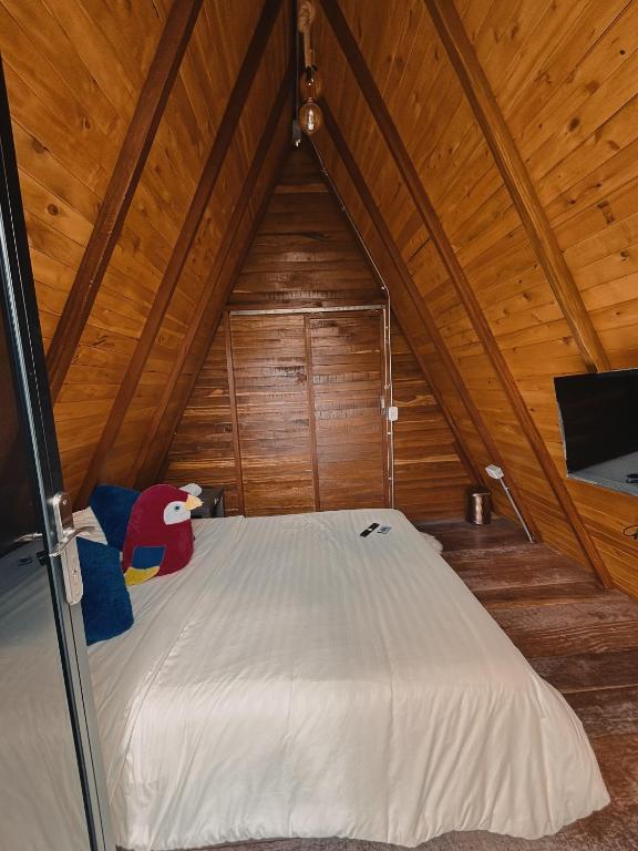 a bed in a room with a wooden ceiling at Glampling Dos Quebradas in Floridablanca