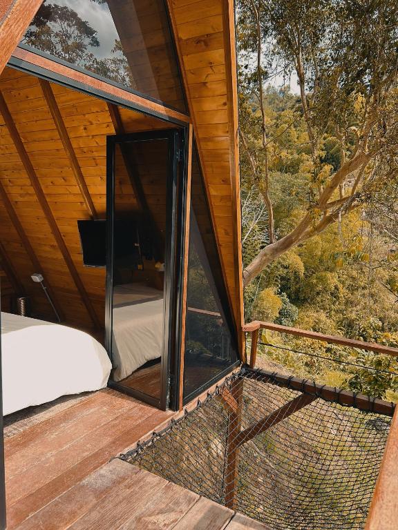 a room with a window and a bed on a deck at Glampling Dos Quebradas in Floridablanca