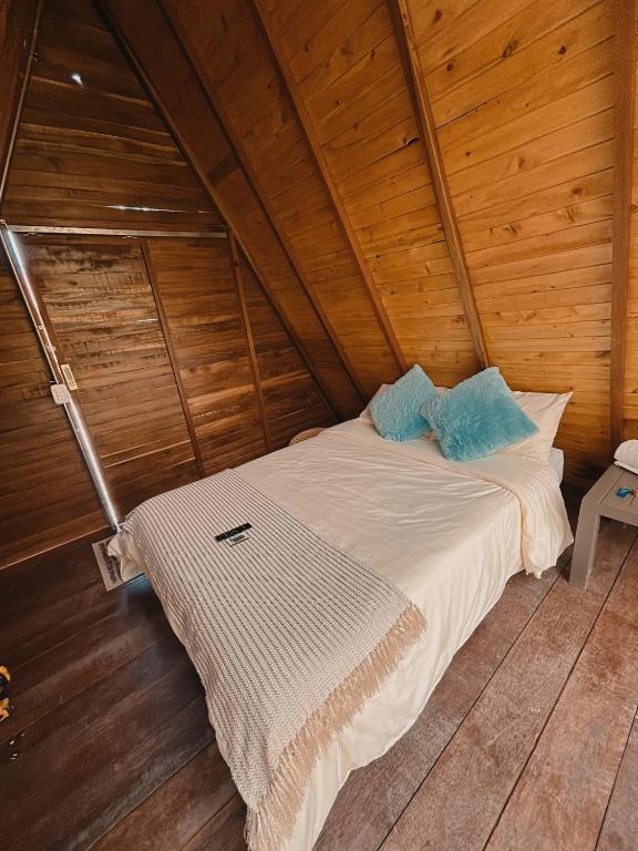 a bed in a room with a wooden ceiling at Glampling Dos Quebradas in Floridablanca