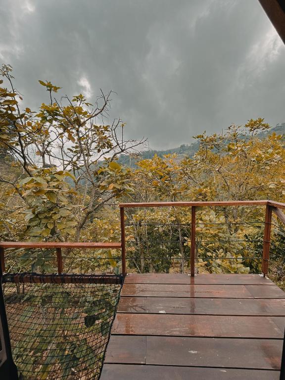 a wooden deck with a view of the mountains at Glampling Dos Quebradas in Floridablanca