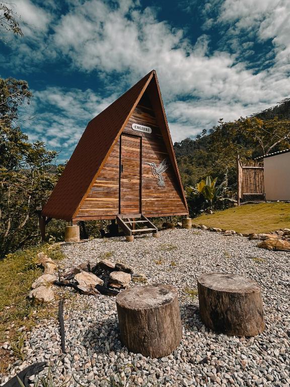 a small cabin with two logs in front of it at Glampling Dos Quebradas in Floridablanca