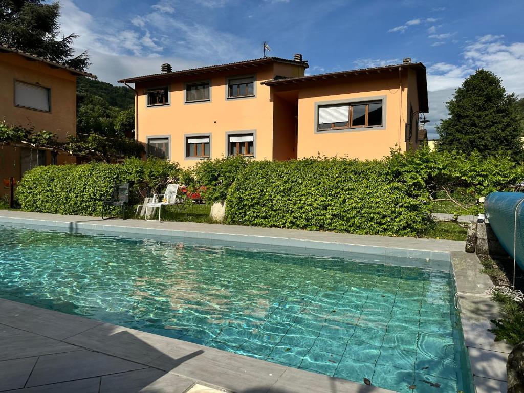 una casa con piscina frente a una casa en Casa vacanza Hydrangea con piscina e giardino, en Bagni di Lucca