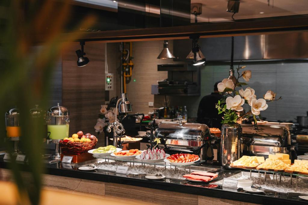 A hot breakfast buffet with fruit, cold dishes, drinks and covered serving trays.