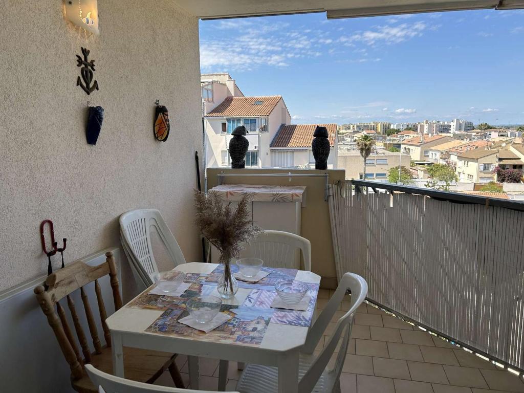 une table et des chaises sur un balcon avec vue dans l'établissement Appt Climatisé 4 Pers avec Piscine et Parking, Plage à 200m - FR-1-250-269, au Grau-du-Roi