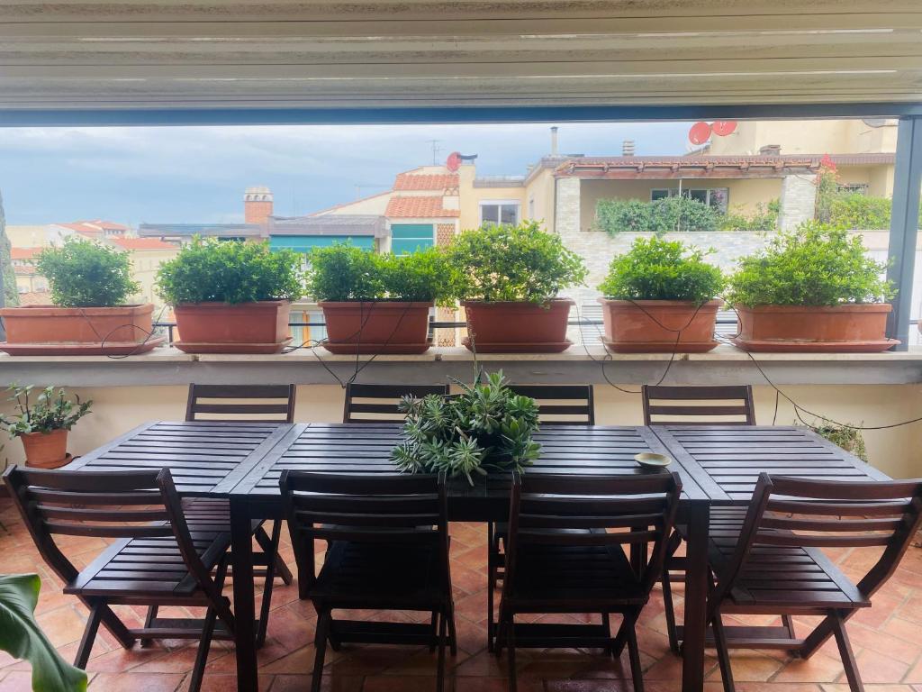 uma mesa e cadeiras numa varanda com vasos de plantas em La casa di Dani em Florença
