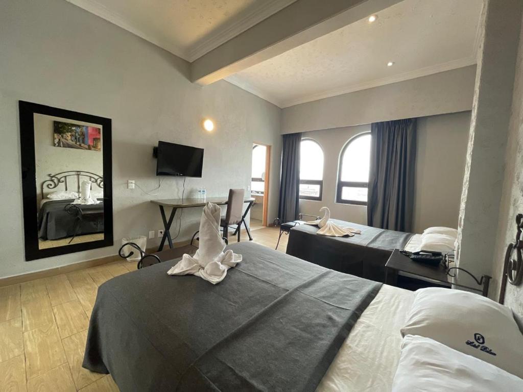 ein Hotelzimmer mit einem Bett und einem Schreibtisch in der Unterkunft Hotel Palace Puebla in Puebla