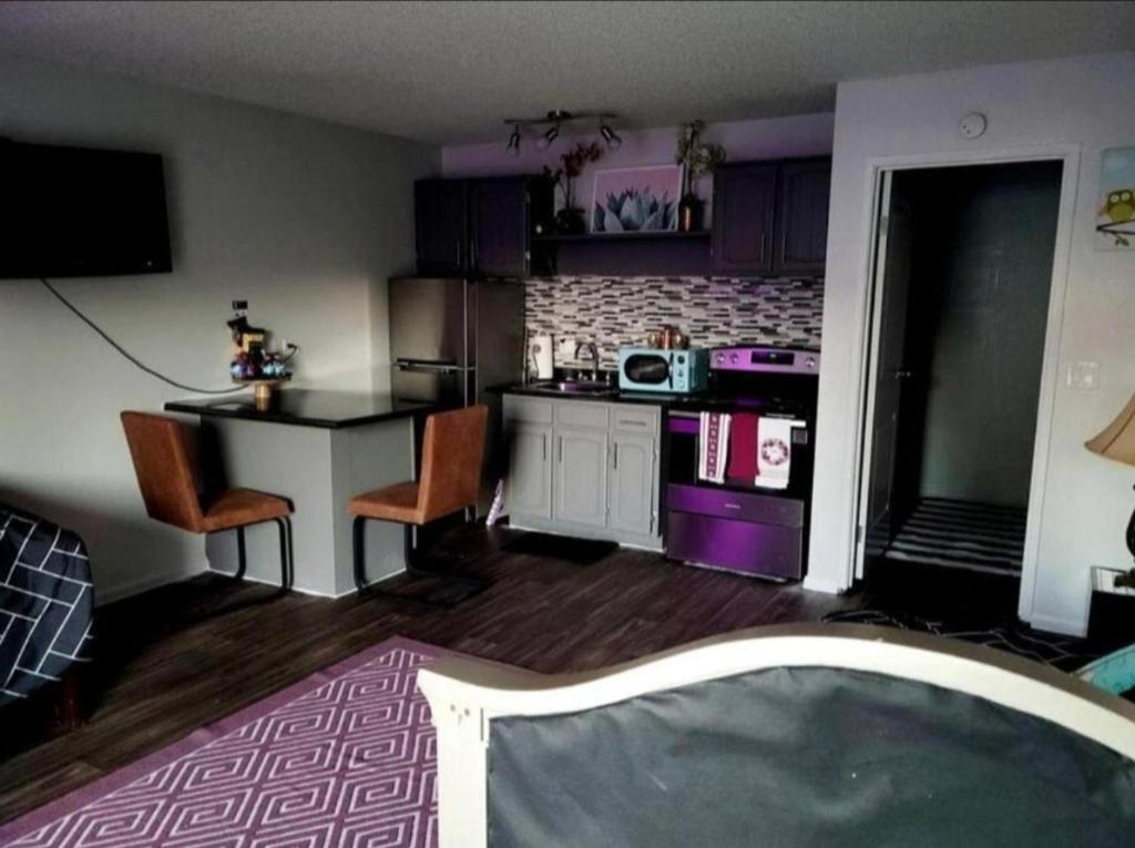 a kitchen with a table and a kitchen with purple at Unlv Cox studio in Las Vegas