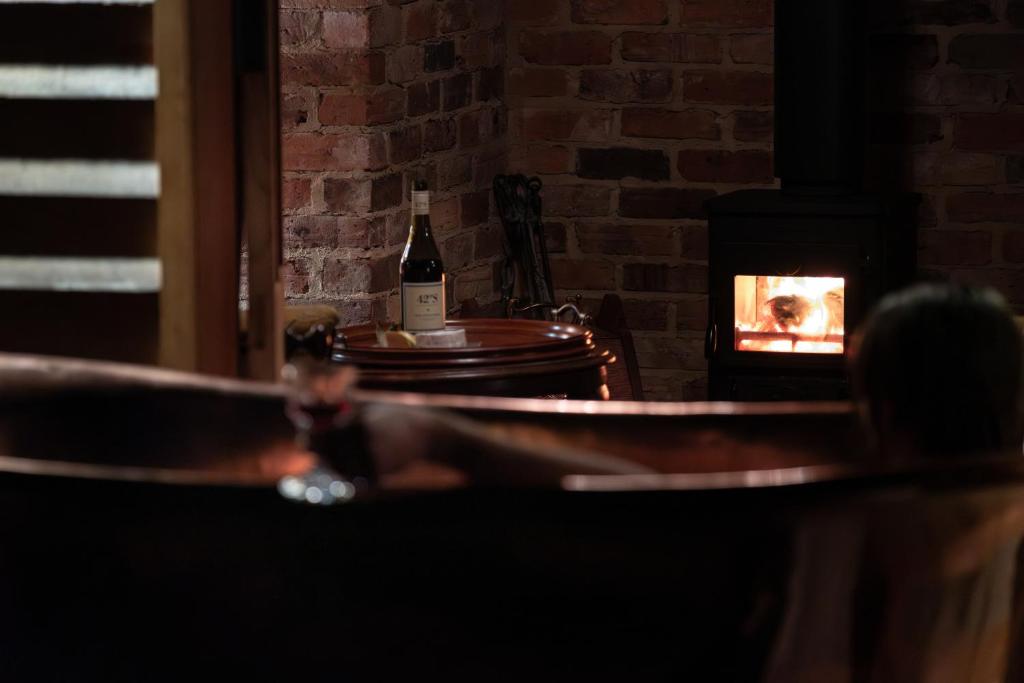 a bottle of wine sitting on a table with a fireplace at Old Bishop's Quarters Hobart in Hobart