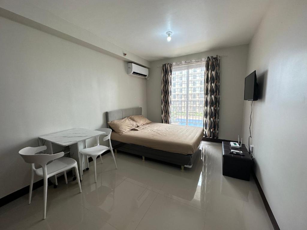 a small room with a bed and a table and a window at Lapu-Lapu City Condo in Lapu Lapu City