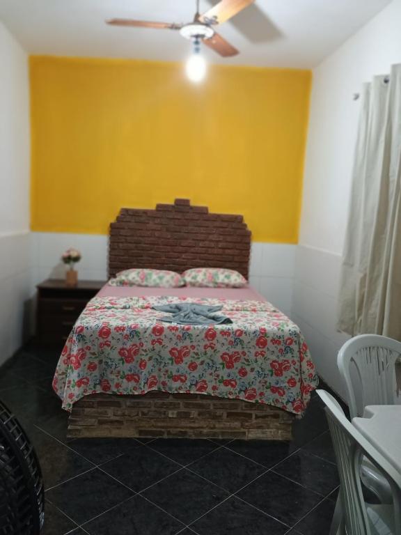 1 dormitorio con cama y pared amarilla en Pousada Villa do Mar, en Itaparica