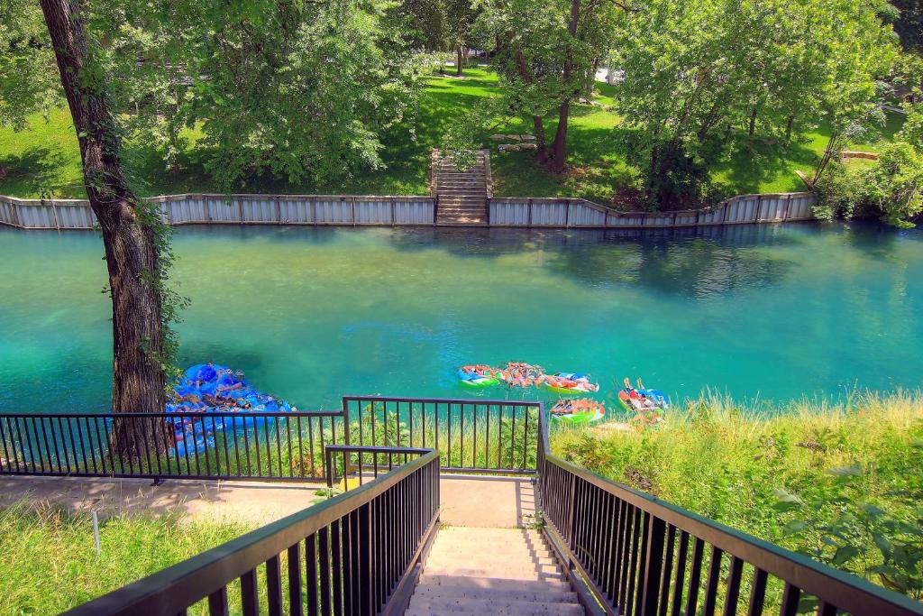 uma grande piscina de água azul com uma cerca de madeira em Fun on the Comal CW C104 em New Braunfels