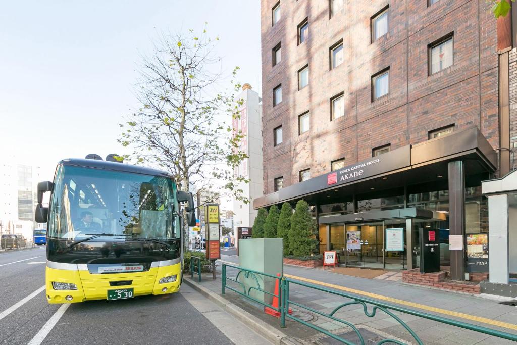 um autocarro amarelo está estacionado numa paragem de autocarro em Ginza Capital Hotel Akane em Tóquio
