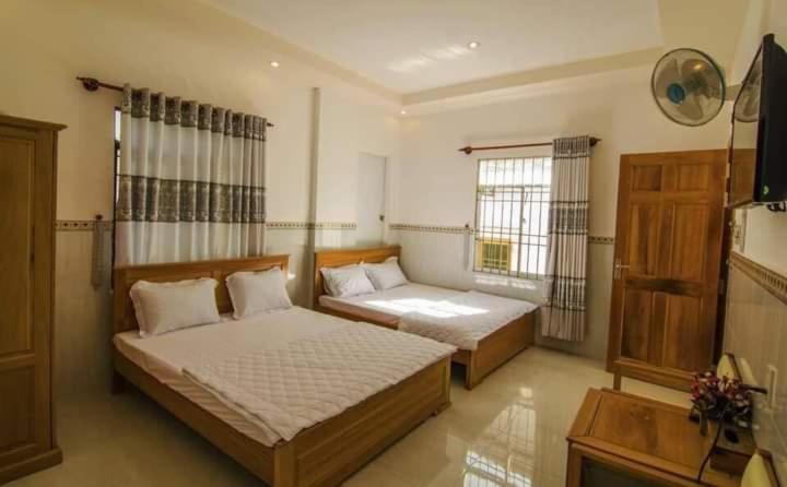a bedroom with two beds and a tv in it at Mỹ Tươi Hotel PQ - by BAY LUXURY in Phu Quoc
