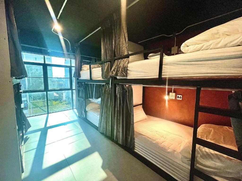 チェンマイにあるLita Guesthouseの二段ベッド3組、窓が備わる客室です。