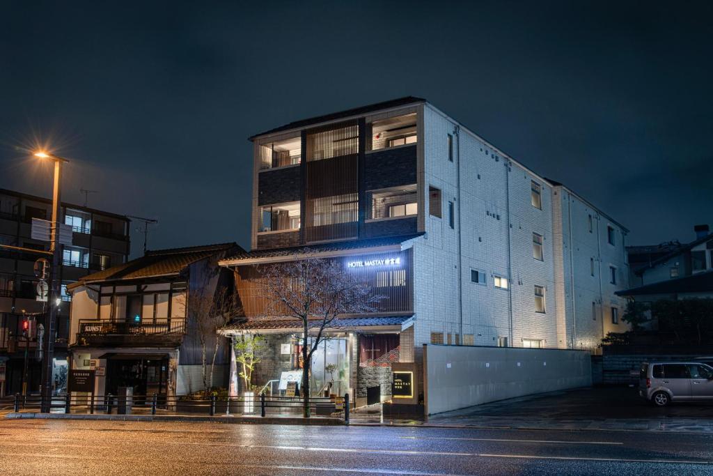 un edificio en una calle de la ciudad por la noche en HOTEL MASTAY jingumichi en Kyoto