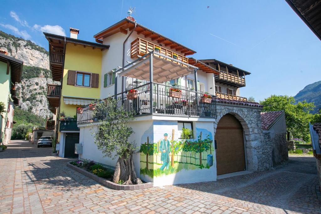 ein gelbes und weißes Gebäude mit einem Balkon in der Unterkunft Casa Del Sole Apartments - Happy Rentals in Arco